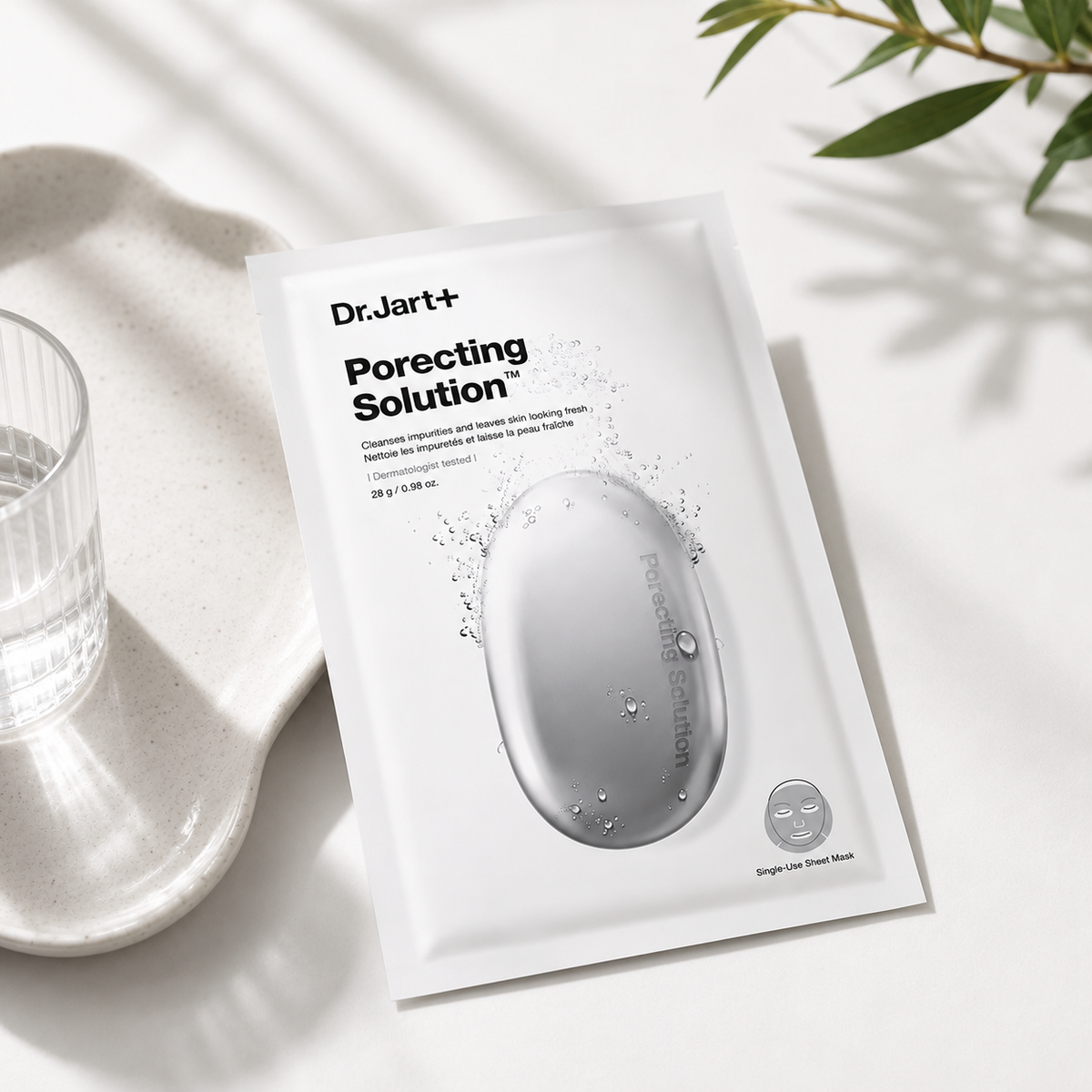 Dr.Jart+ Porecting Solution Bamboo Charcoal Sheet Mask elegantly displayed in a bright spa-inspired setting with soft natural light, ceramic tray, glass accents and botanical elements, highlighting its deep-cleansing, pore-tightening and oil-balancing benefits while creating a clean, premium skincare atmosphere.